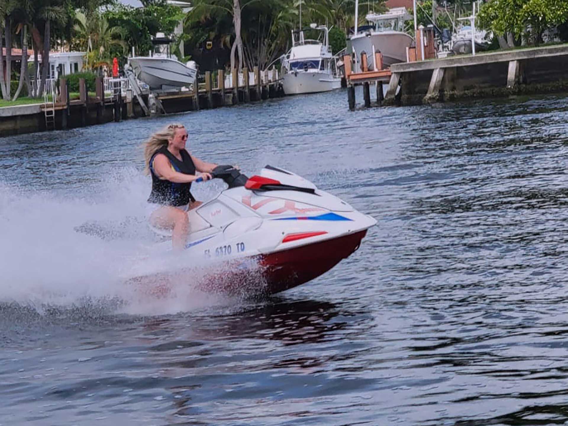 A woman riding a jet ski while passing homes